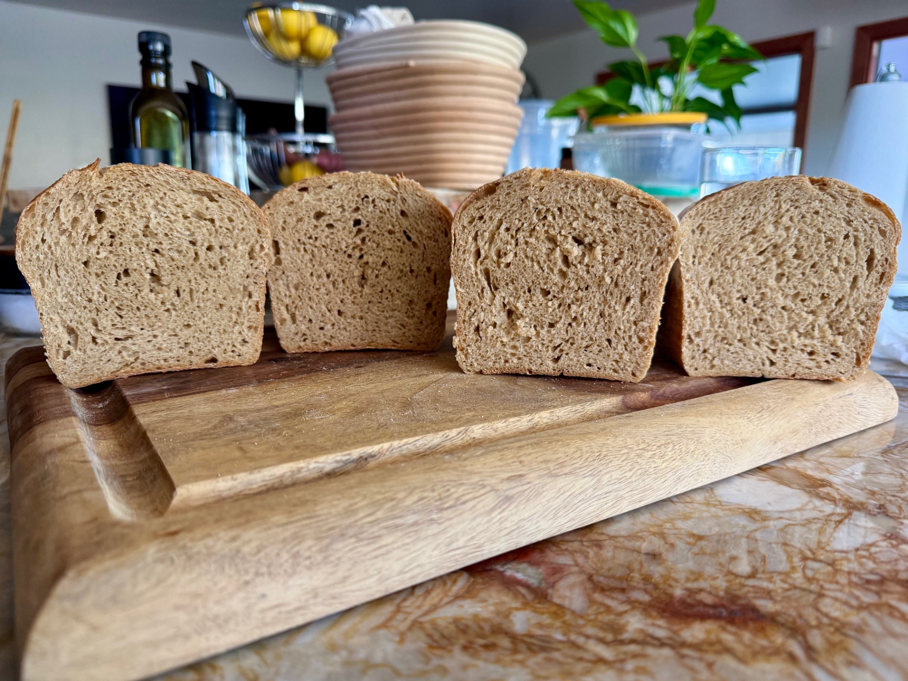 Four daily sandwich loaves sliced open, showing a soft even crumb